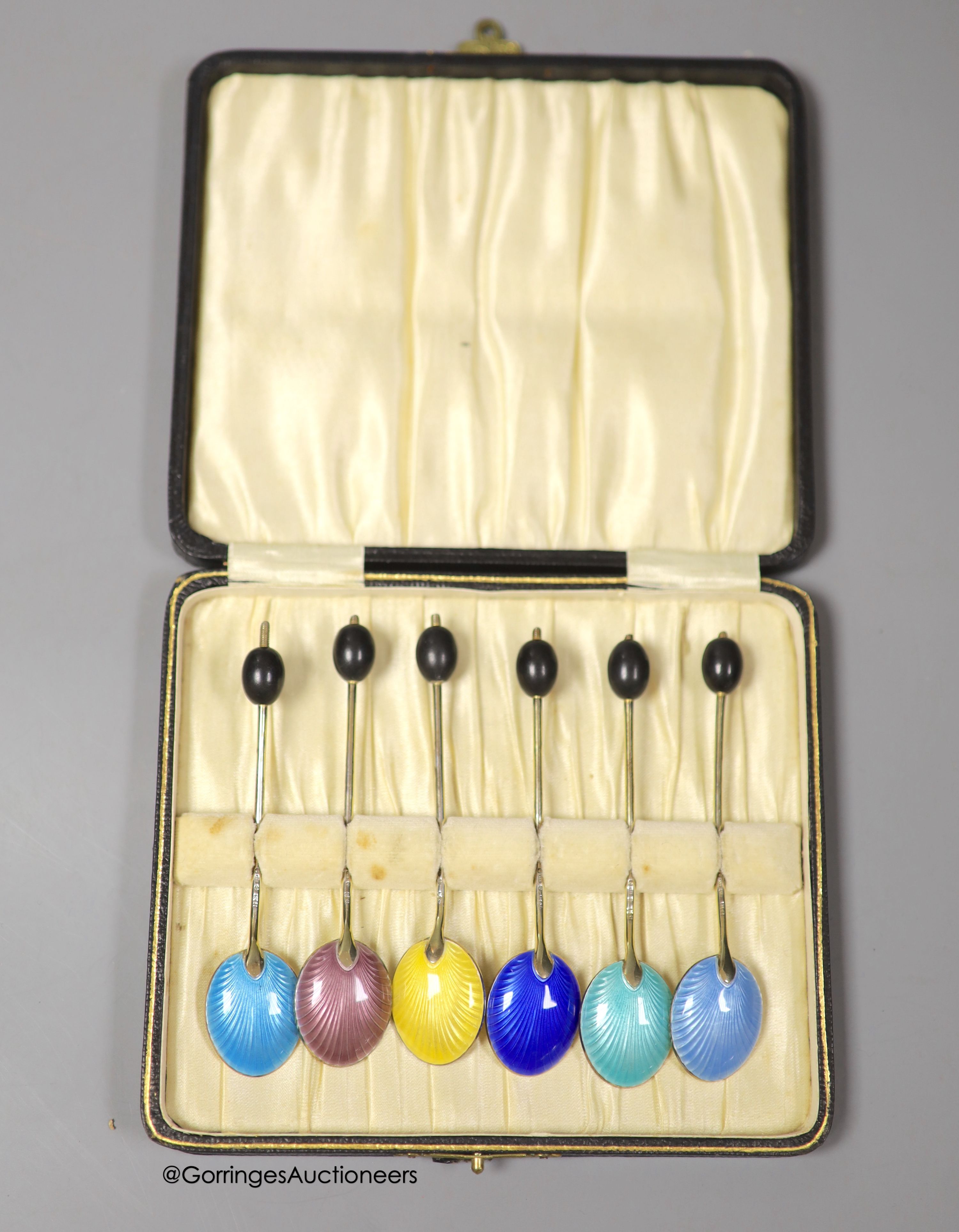 A late 1920's cased set of six continental silver and enamel bean end coffee spoons, import marks for George Stockwell, London, 1929, 9.9cm.